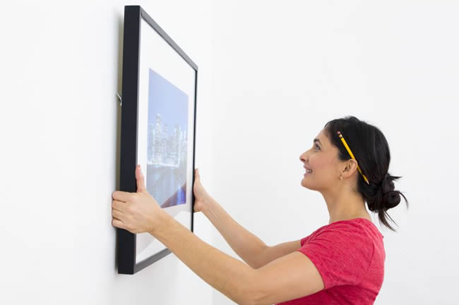 Woman hanging painting